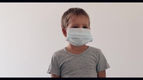 ウイルス感染を避けるために顔の使い捨てマスクを着用少年 コロナウイルスを止めろ — ストック動画
