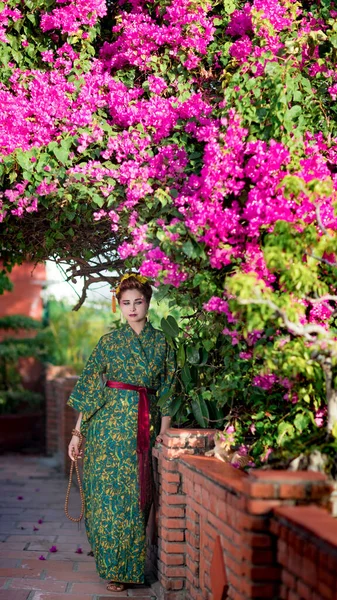 日本艺妓风格的漂亮女子穿着和服在花园里的艺术肖像 — 图库照片