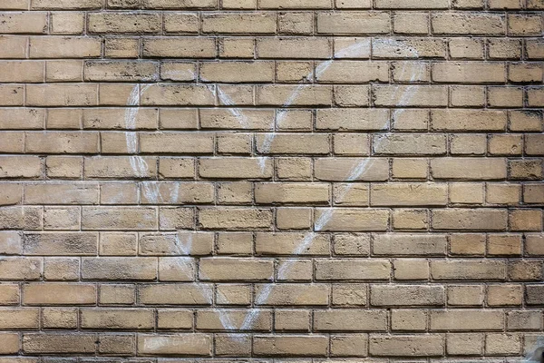 Heart sign drawn by white chalk on brick wall