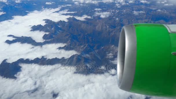 Vacker utsikt genom flygplan fönster, flygplan som flyger över molnen och bergen — Stockvideo