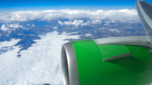 Vacker utsikt genom flygplan fönster, flygplan som flyger över molnen och bergen — Stockvideo