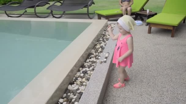 Menina de dois anos perto da piscina do hotel — Vídeo de Stock