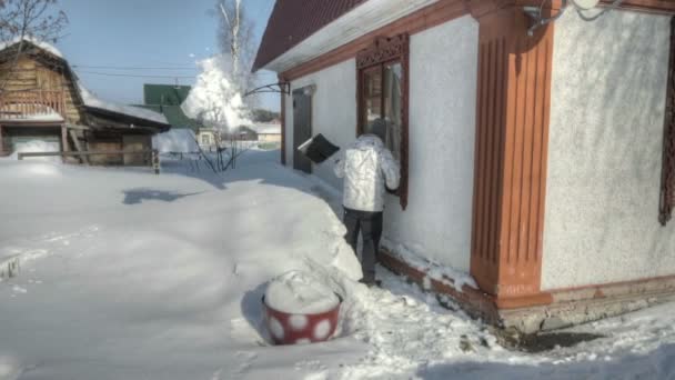 Человек убирает снег после снежной бури — стоковое видео
