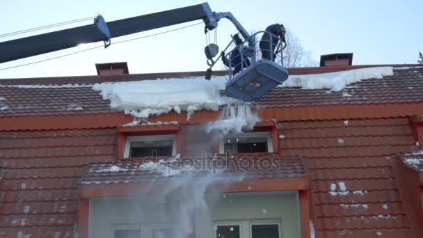 Ouvrier déneigeant sur le toit du bâtiment — Video