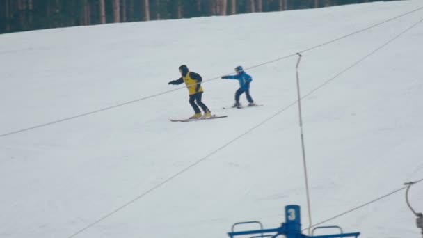 Un moniteur de ski apprend à un enfant à skier — Video