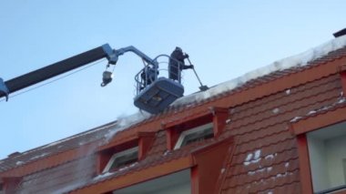 Binanın çatısında kar kaldırma işçi