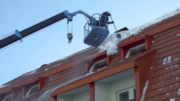 Pracownik, usuwania śniegu na dachu budynku — Wideo stockowe