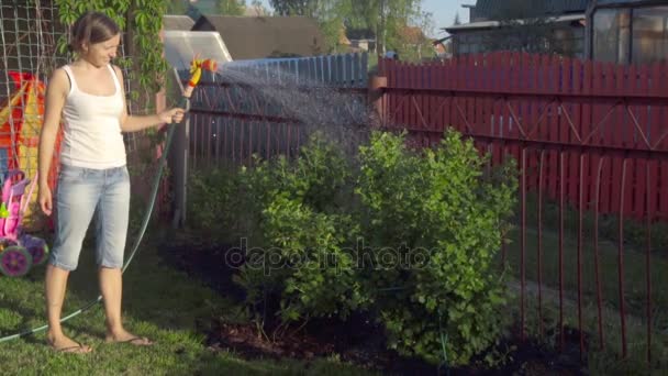 Жінка поливає газон — стокове відео