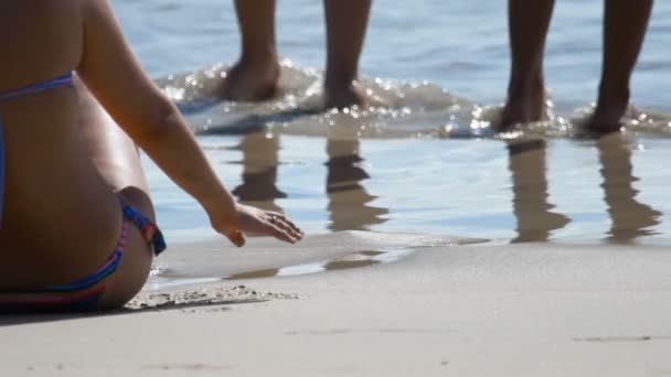 Pies masculinos y femeninos están de pie en la playa de arena — Vídeos de Stock