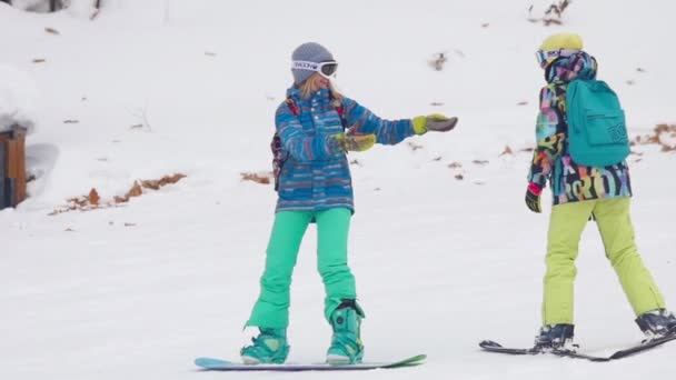 Skifahrer und Snowboarder entspannen im Skigebiet der Berge — Stockvideo