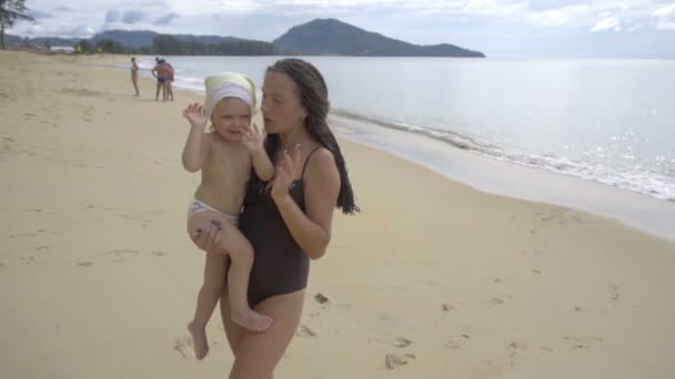 Moeder met een twee-jaar-oude dochter wandelen langs het zandstrand — Stockvideo