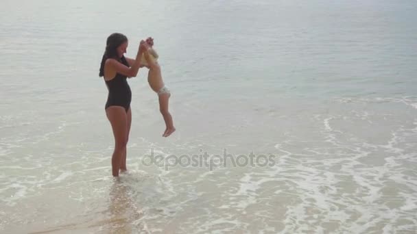 Mãe com uma filha de dois anos andando ao longo da praia — Vídeo de Stock