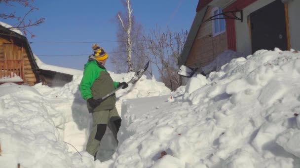 Человек убирает снег после снежной бури — стоковое видео