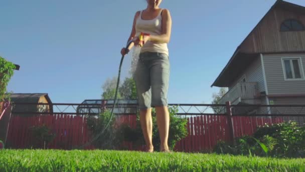 Kvinna vattna gräsmattan — Stockvideo