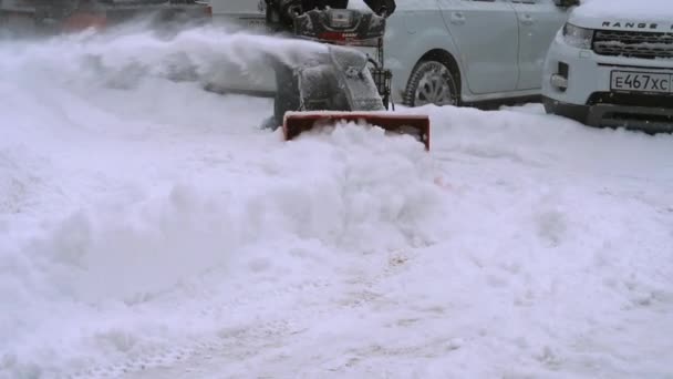 Человек со снегоуборочной машиной работает — стоковое видео