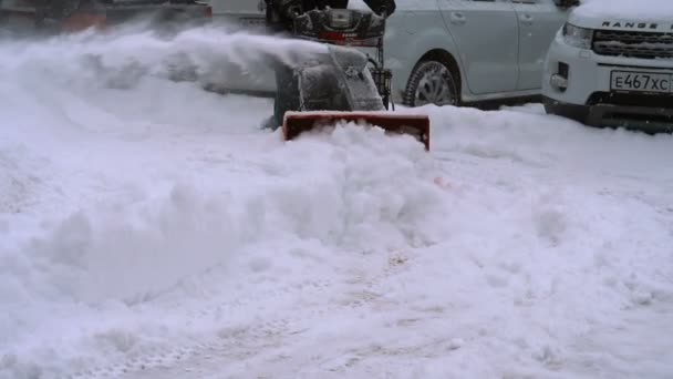 Hombre con una máquina de soplado de nieve trabajando — Vídeos de Stock