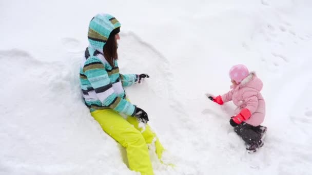 Mãe com uma filha de três anos de idade jogar bolas de neve — Vídeo de Stock
