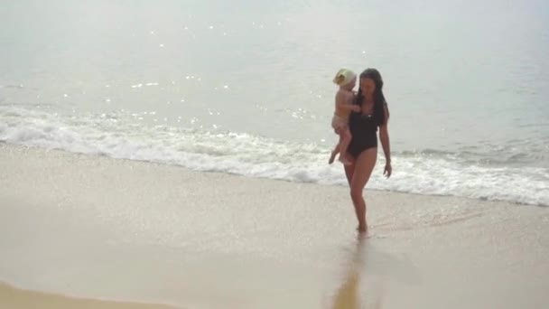 Mãe com uma filha de dois anos andando ao longo da praia — Vídeo de Stock