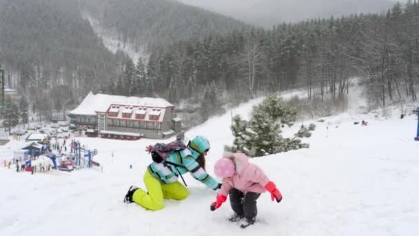 Mutter mit dreijähriger Tochter spielt Schneebälle — Stockvideo