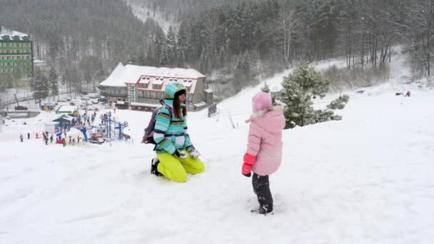 Mom with a three-year-old daughter play snowballs — Stock Video