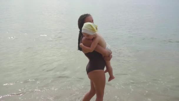 Mamma con una figlia di due anni che cammina lungo la spiaggia di sabbia — Video Stock