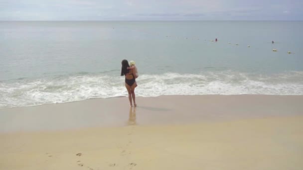Mãe com uma filha de dois anos andando ao longo da praia — Vídeo de Stock
