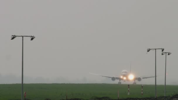 Widebody vliegtuig landing bij regenachtig weer — Stockvideo