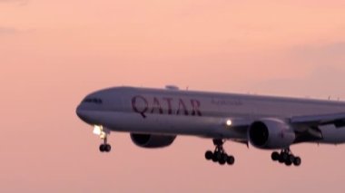 Gün batımında okyanus üzerinden yaklaşan uçak.