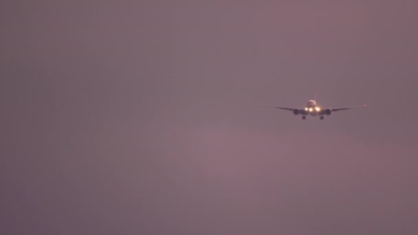 Avion approchant au-dessus de l'océan au coucher du soleil — Video