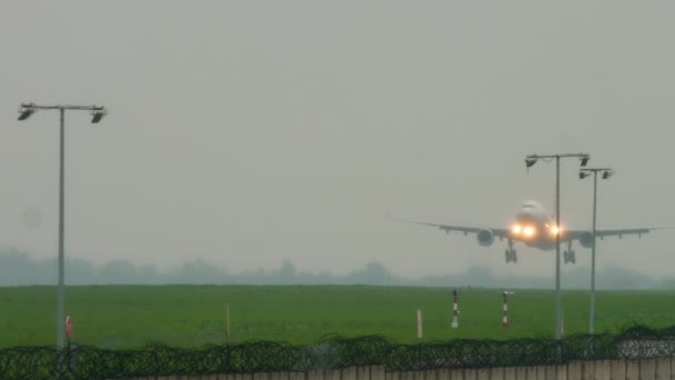 Widebody vliegtuig landing bij regenachtig weer — Stockvideo