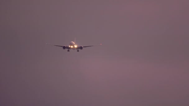 Avion approchant au-dessus de l'océan au coucher du soleil