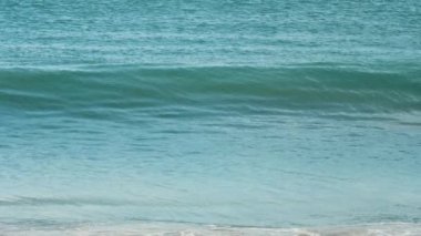 Gök mavisi dalgalar Mai Khao Sahili 'nin kıyısına vurdu.