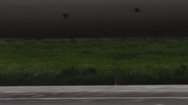 Geniş gövdeli uçak yağmurlu havada iniyor, yakın plan.