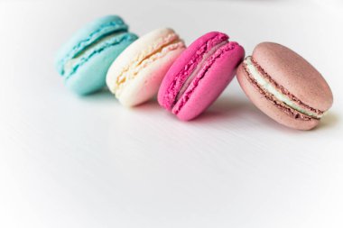 Macaron pasta, mavi, pembe, sarı, kahverengi beyaz arka plan üzerinde