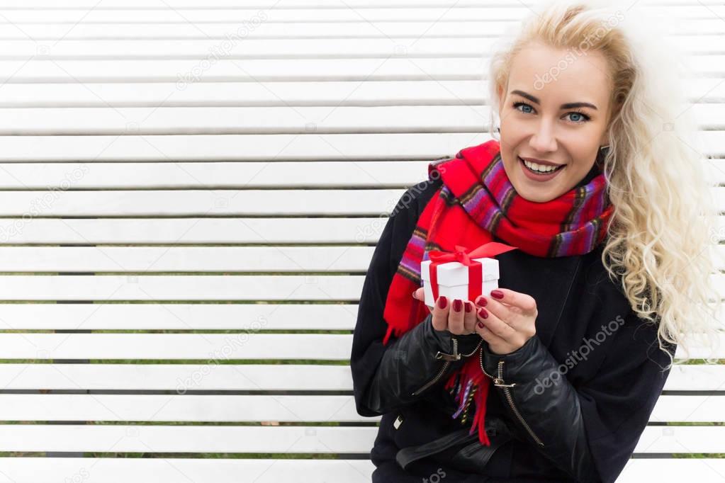 Beautiful Blonde Girl Holding a Gift in Their Hands. Copy Space