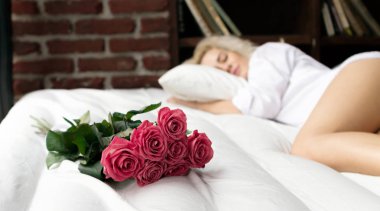 Uyku genç kadın bir arka plan üzerine gül buketi