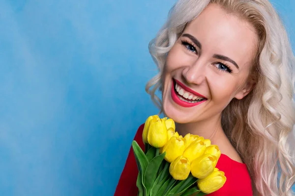 Hermosa mujer europea con un ramo de tulipanes. Concepto de primavera — Foto de Stock