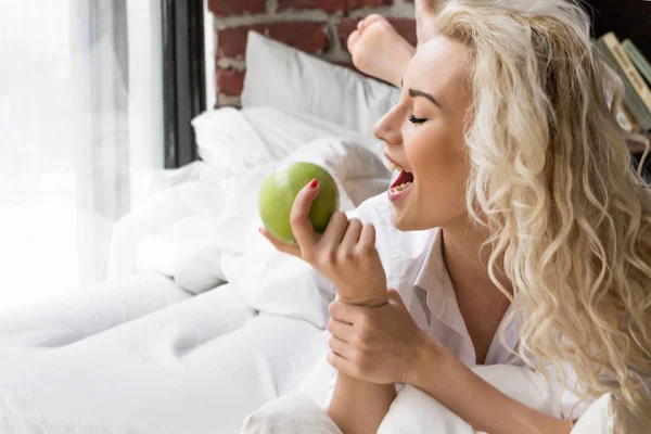Hermosa mujer desayunando en la cama con manzana — Foto de Stock