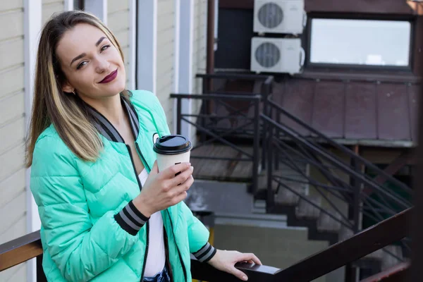Щаслива жінка п'є каву в місті — стокове фото
