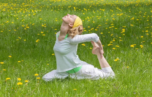 Женщина на травяной йоге — стоковое фото
