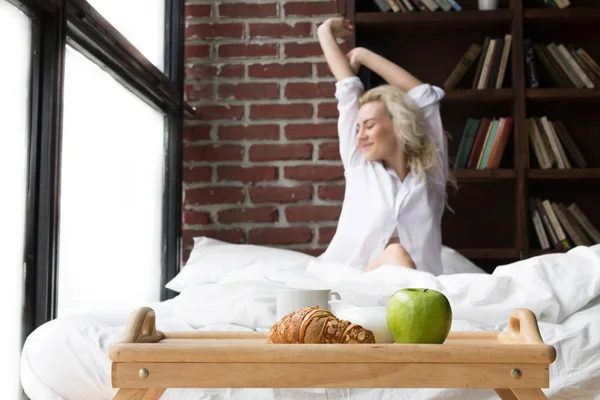 Mujer joven desayunando en la cama — Foto de Stock