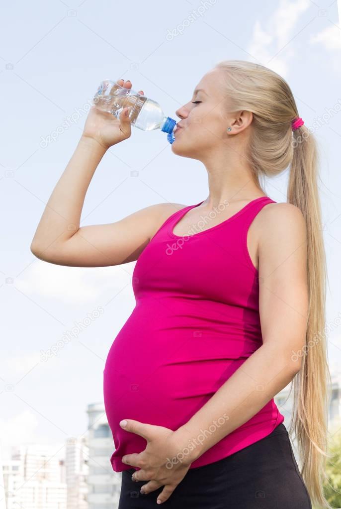 Pregnant Active Girl Drinks Water Outdoors
