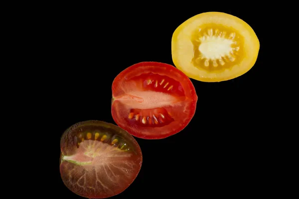 Diferente mitad de los tomates en un fondo negro —  Fotos de Stock