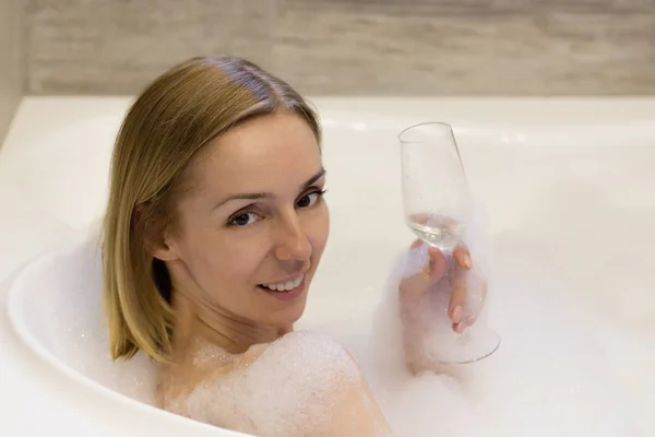 Retrato de una mujer feliz en un baño con vino — Foto de Stock