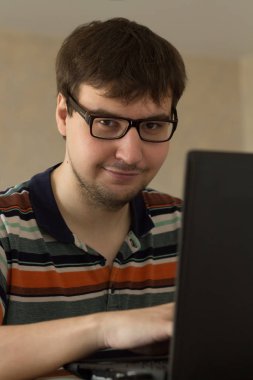 genç adam arkasında bir dizüstü bilgisayar