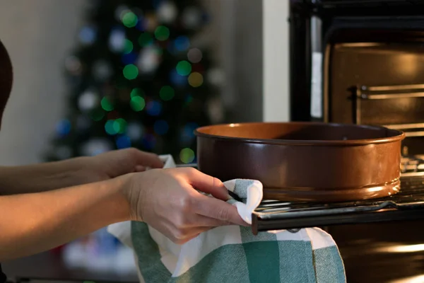 A Woman Gets a Pie Out of the Oven. Christmas Concept — Stock Photo, Image