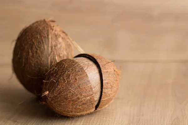 Hela och trasiga kokosnötter på brun bakgrund — Stockfoto