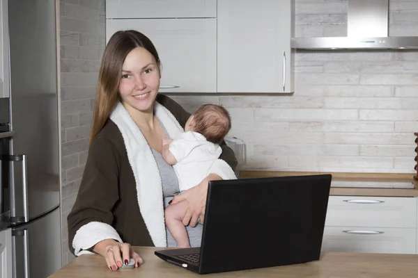 Portrait of a Young Mom with a Child at a Computer