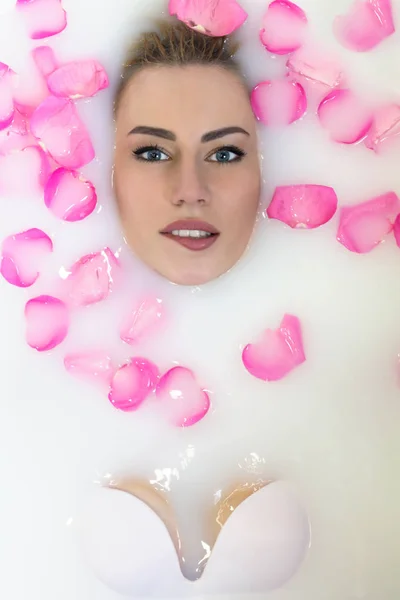 沉浸在沐浴中的感性女人与牛奶和花朵 — 图库照片