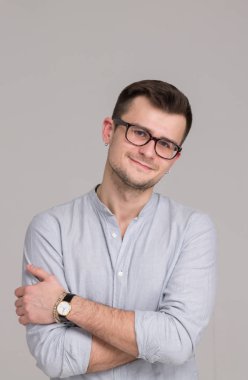 Modern genç adam gri bir arka plan üzerinde izole bir gömlek